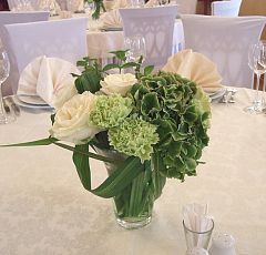 Композиции на столы для гостей — Бело-зеленая свадьба. Небольшие композиции в стеклянных вазах на столы для гостей. Крупные белые розы, зеленая гортензия и гвоздика, белая минигербера, веточки душистой мяты, аранжировочная зелень.