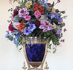 Композиция из искусственных цветов в сине-золотой винтажной вазе