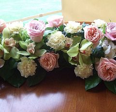  Свадебное оформление в гольфклубе Целеево — Цветы на стол жениха и невесты. Вытянутая композиция-бордюр из нежно-розовых садовых роз, зеленых орхидей цимбидиум и гвоздики цвета шампанского.