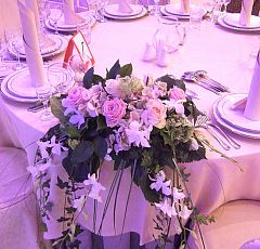 Немчиновка Парк. Свадебное оформление — Цветочные композиции для гостей расположены на крае стола лицом к основной сцене. Ниспадающие линии плюща и берграсса, бело-розовая гамма.