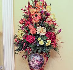 Композиция из искусственных цветов в высокой вазе