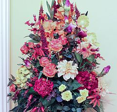 Композиция из искусственных цветов в высокой вазе